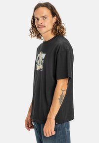 Sort bomuld t-shirt med korte �ærmer, der har et grafisk trykdesign på fronten, rund halsudskæring og afslappet pasform.