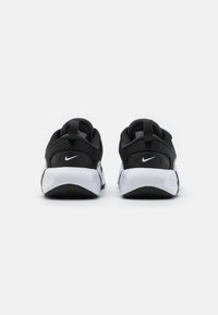 Zwarte Nike sneakers met een textuur op de bovenkant, een contrasterende witte zool en een opvallend logo op het hielpaneel.