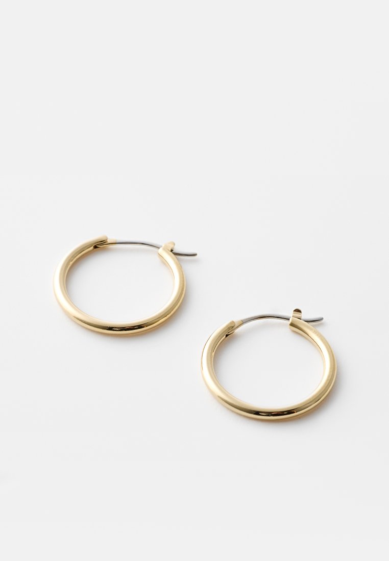 Goldfarbene Creolen mit einem glatten, runden Design und einem Scharnierverschluss. Hergestellt aus Metall, mit einer glänzenden Oberfläche.