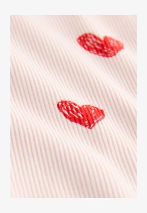 Geribd stof in lichtroze met twee geborduurde rode harten, met een gestructureerd ontwerp.