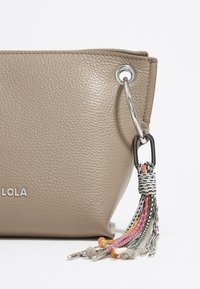 Borse a pochette in pelle beige con superficie testurizzata, hardware argentato e dettagli con nappina multicolore adornati da catene e cordini.