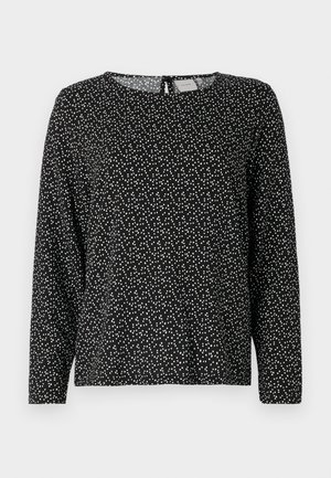 Mustast pikkade varrukatega särk ümmarguse kaelusega, millel on hajus valgete punktide muster ja lukuga seljaosa. Kerge kangas.