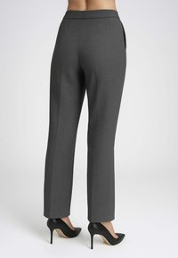 Pantaloni grigi su misura con una texture liscia, dotati di vita aderente, tasche posteriori e design a gamba dritta abbinati a tacchi alti neri.