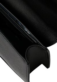 Clutch in pelle nera con finitura testurizzata, dotata di chiusura a zip e fodera interna liscia. Forma compatta con bordi arrotondati.