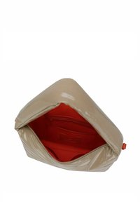 Clutch de charol beige con forma triangular. El interior cuenta con un forro rojo brillante y un bolsillo con cremallera. Cierre de cremallera visible.