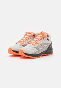 Zapatos de senderismo grises con acentos naranjas. La parte superior presenta un patrón texturizado, cordones y una suela de goma negra para tracción. Diseño ligero.