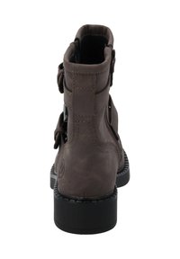 Bota tobilleras de imitación de cuero marrón con detalles de costura, cremallera lateral y adornos de hebilla ajustable. Suela de goma negra con un ligero tacón.