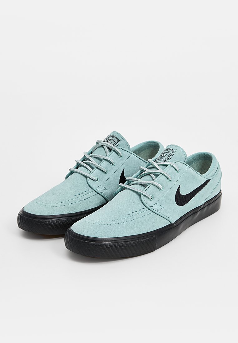 Zapatillas de ante azul claro con detalles en negro, que presentan un diseño con cordones, punta redonda y suela de goma negra texturizada.