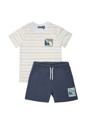 Camiseta blanca de manga corta con finas rayas amarillas y pantalones cortos azul marino, ambos con parches gráficos que dicen "Volver a la naturaleza".