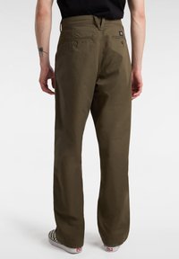 Olivgrön, vida byxor i en lättviktig tyg, med två bakfickor med knapplås och en etikett ovanför den högra fickan.