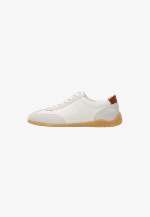 Weißer Sneaker mit niedrigem Schaft aus Leder und beigen Wildleder-Akzenten, honigwabenmusterte Gummisohle, weiße Schnürsenkel und brauner Fersenlasche.