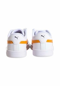 Scarpe sportive bianche con accenti arancioni, materiale sintetico liscio, forma arrotondati e collo imbottito. Presenta il logo vicino al tallone.