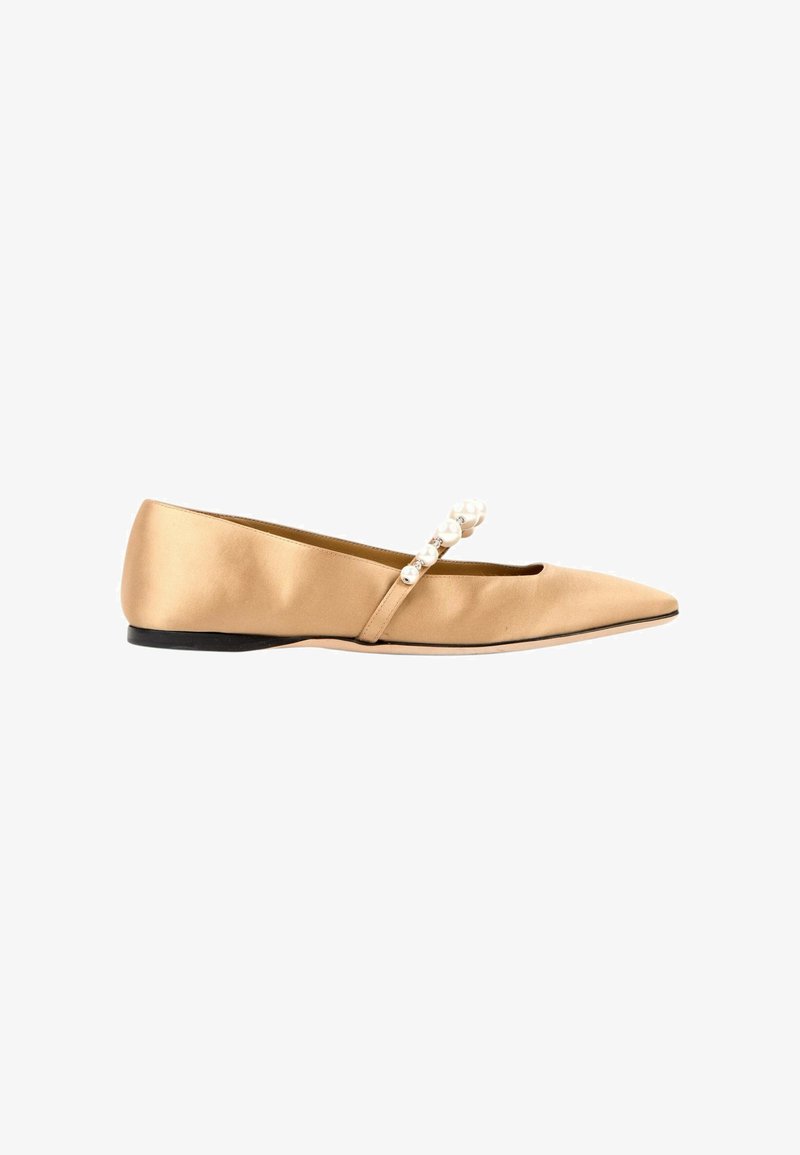 Chaussure plate en satin beige à bout pointu, semelle noire et bride ornée de perles blanches traversant le dessus.