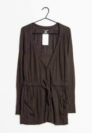 Cardigan long à manches longues marron foncé avec poches avant, ceinture à nouer et décolleté en V profond, suspendu sur un cintre noir contre un fond blanc.