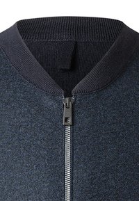 Dunkelblaues Zip-Up Sweatshirt aus strukturierter Stoff, mit geripptem Kragen und einem Metallreißverschluss mit einem kleinen Ziehgriff.
