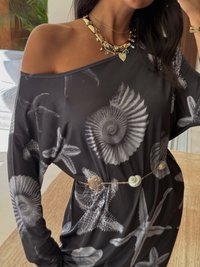 Vestido preto com ombros à mostra, apresentando um padrão de conchas e estrelas-do-mar. A peça conta com um cinto texturizado com detalhes em conchas e metal.