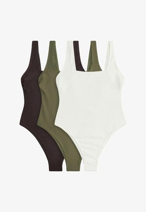 Trzy prążkowane topy na ramiączkach w kolorze czarnym, oliwkowym i białym, ułożone na sobie na białym tle.