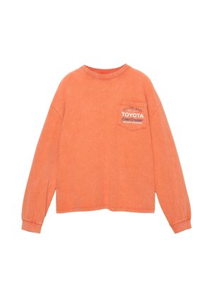 Pomarańczowa koszula z długim rękawem i okrągłym dekoltem, z kieszonką na piersi i białym logo "TOYOTA Land Cruiser". Miękka, teksturowana tkanina.