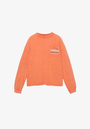 Oranje langwerpig T-shirt met ronde hals, voorzien van een borstzak en het "TOYOTA Land Cruiser" logo gedrukt in het wit. Zachte, gestructureerde stof.