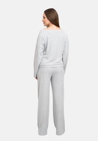 Set di abbigliamento casual grigio realizzato in tessuto morbido; presenta una maglietta a maniche lunghe ampia e pantaloni a gamba larga. Nessun motivo distintivo o hardware.