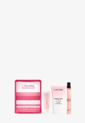 Pink-weißes Lancome Beach Club Kosmetiktäschchen mit Juicy Tubes Gloss, Hydra Zen Gel-Creme und Idole Parfümspray daneben arrangiert.