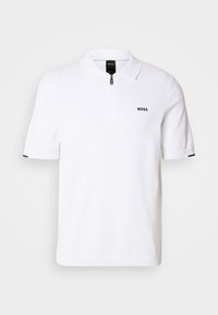 Polo blanc à manches courtes, doté d'un col zippé, d'un logo brodé discret et d'accents contrastants aux ourlets des manches.