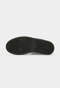 Μαύρη σόλα αθλητικού παπουτσιού Nike με κυκλικό πέλμα μπροστά, ορθογώνια σχέδια στη φτέρνα και το λογότυπο της Nike κοντά στο κέντρο.