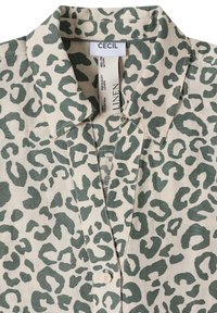 Chemise en lin beige à col avec imprimé léopard vert irrégulier et boutons, étiquetée « Cecil » et fabriquée en tissu de lin.