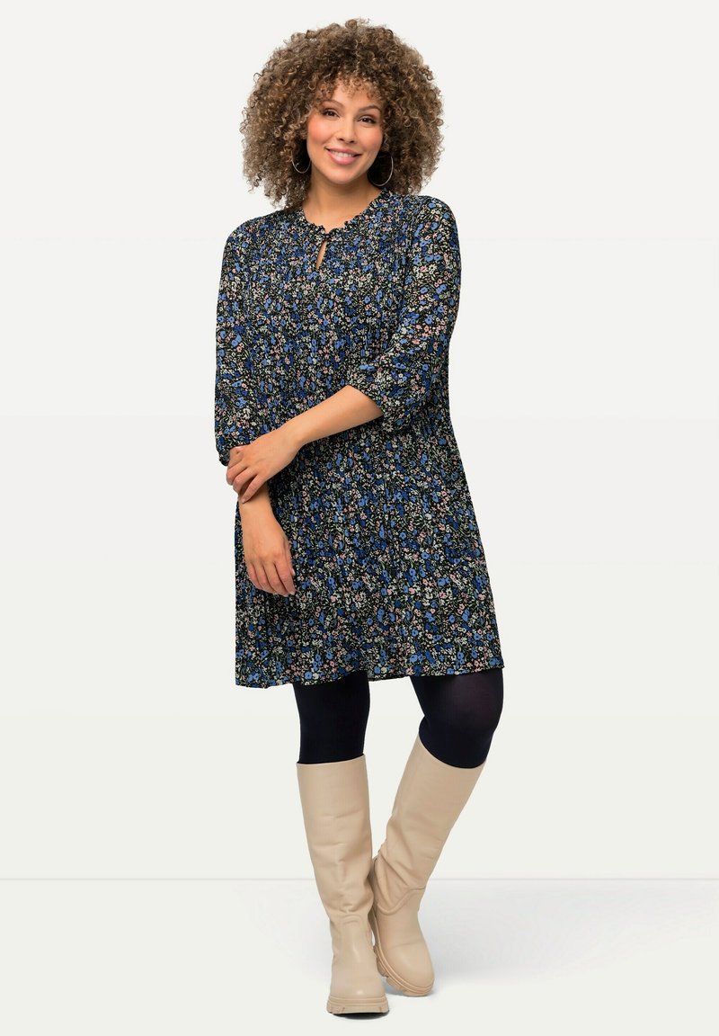 Floral dress with three-quarter sleeves, blue and black fabric, gathered waist, knee-length, paired with knee-high beige boots.