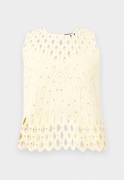 Haut crème sans manches avec motifs découpés au laser et petites décorations en strass, présentant des bords festonnés à l'ourlet et à l'encolure.