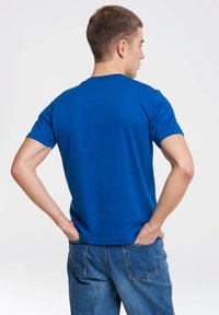 Blue short-sleeve t-shirt in cotton fabric with a crew neckline. The design features a plain back with no visible logos or patterns.