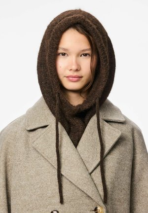 Brun ullig scarf med huva, i kombination med en ljusgrå dubbelknäppt kappa med utskurna slag och guldknappar.