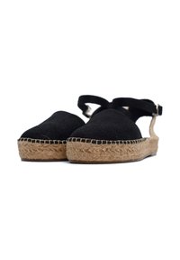 Czarne espadryle na niskim obcasie z paskiem wokół kostki, z midsole owiniętym jute, oraz zaokrąglonym noskiem. Płaska podeszwa z plecionym wykończeniem.