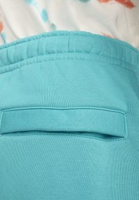 Los pantalones jogger turquesa cuentan con una tela suave y elástica, con una cintura cosida y un pequeño bolsillo trasero para almacenamiento.