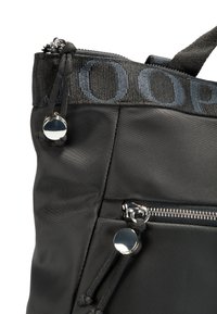 Borsa nera in nylon con tasca con zip, tracolla testurizzata con logo e dettagli in metallo. Presenta chiusura con lacci.