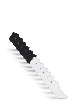 Acht Paare schwarze Knöchelsocken und acht Paare weiße Knöchelsocken diagonal auf weißem Hintergrund angeordnet.