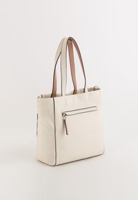 Tote-Bag aus cremefarbenem Leder mit schwarzem Besatz und braunen Doppelriemen. Verfügt über eine externe Reißverschlusstasche auf einer Seite. Glatte Textur.