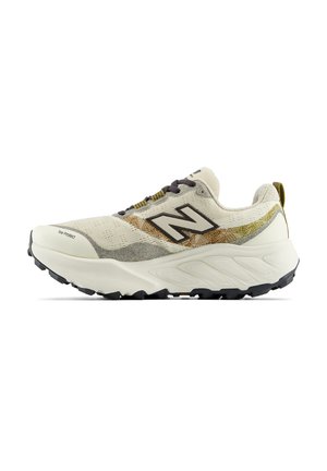 Μπεζ και γκρι αθλητικό παπούτσι New Balance με παχιά λευκή σόλα, μαύρο πέλμα, μαύρο λογότυπο, καφέ και κίτρινες λεπτομέρειες και μαύρα κορδόνια.