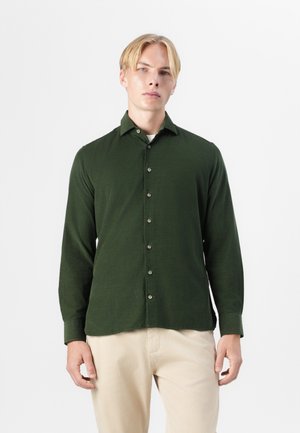 Chemise boutonnée vert foncé avec un col et des manches longues. Présente une texture subtile et de légers boutons sur le devant.
