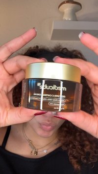 Brązowy szklany słoik z złotą pokrywką, oznaczony etykietą „medicud” dla kremu z witaminą C. Przejrzysty tekst podkreśla szczegóły produktu z przodu.