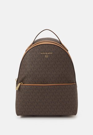 Bruine Michael Kors rugzak met gouden ritssluiting en logo, met monogrampatroon en bovenste draaghendel.