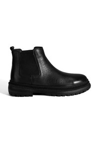 Bottines Chelsea en cuir noir avec surface texturée, panneaux latéraux élastiques et semelle robuste dotée d'un profil à motifs.