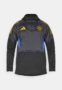 Schwarzer und blauer Sportpullover mit hohem Kragen, Viertelreißverschluss und elastischen Bündchen. Verfügt über gelbe Adidas-Streifen und das Manchester United-Logo.