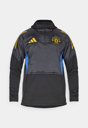 Crni i plavi atletski pulover s visokim ovratnikom, četvrtim patentnim zatvaračem i elastičnim manžetama. Sadrži žute Adidas pruge i logo Manchester Uniteda.