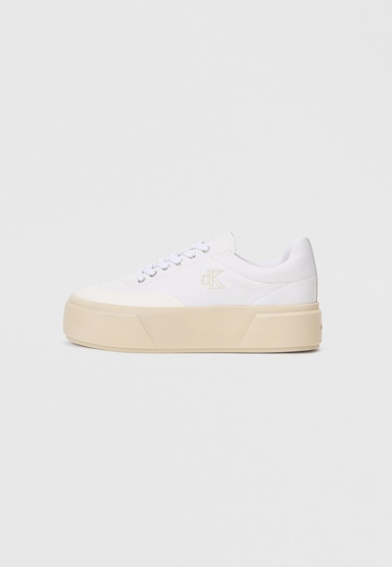 Λευκά καμβά παπούτσια με χοντρή μπεζ σόλα, που διαθέτουν έναν διακριτικό κεντημένο λογότυπο στο πλάι και κλασικό σχέδιο με κορδόνια.