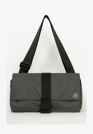 Grau messenger bag aus strukturiertem Stoff, mit einem verstellbaren schwarzen Trageriemen, einem vorderen Deckel und einem runden Logo-Akzent in der Ecke.