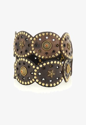 Bracciale polsino in pelle marrone con borchie dorate, elementi circolari in metallo, ritagli a forma di stella e motivi floreali su tutta la superficie. Finitura testurizzata.