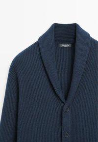Navy ribbed cardigan with shawl collar, featuring three black buttons and soft texture. Tag visible inside, branded "Massimo Dutti."