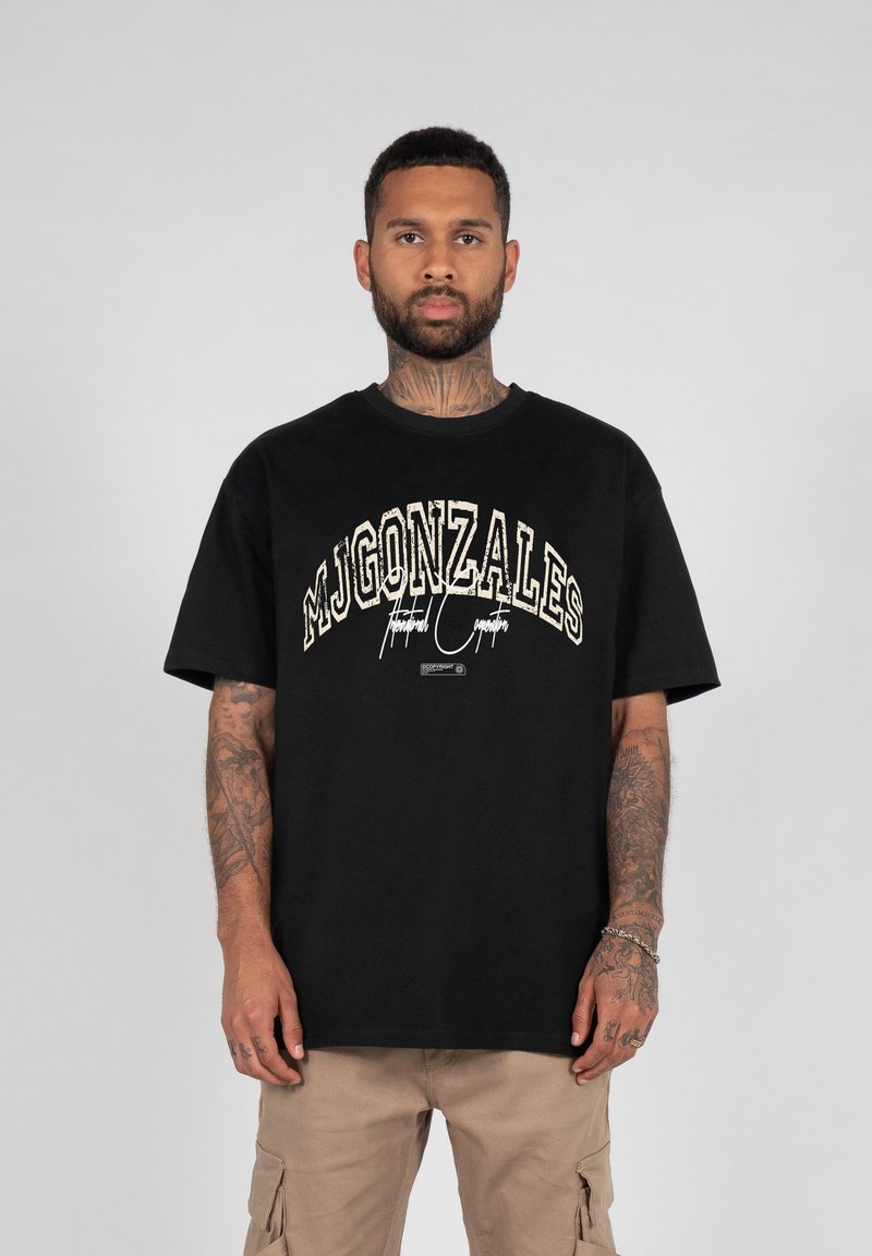 Čierne bavlnené tričko s okrúhlym výstrihom, so širokým bielym a zlatým potlačeným logom na prednej strane a krátkymi rukávmi.