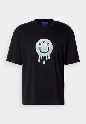 Fekete pamut póló, nagy, fényes, olvadó mosolygós arc dizájnnal, amelybe az "HGO" betűket integrálták. Rövid ujjú.